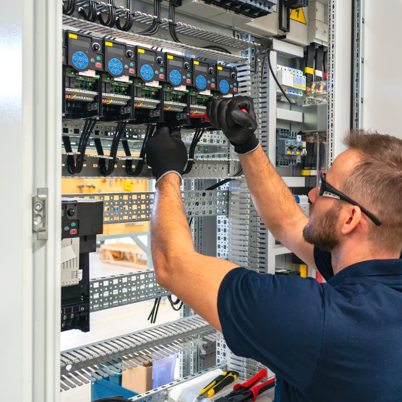 Electrician working inside a commercial electrical panel
